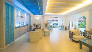 A spacious lobby with a reception desk, seating areas, and a view of the outside. - Ocean Breeze Resort Khao Lak (Takua Pa)