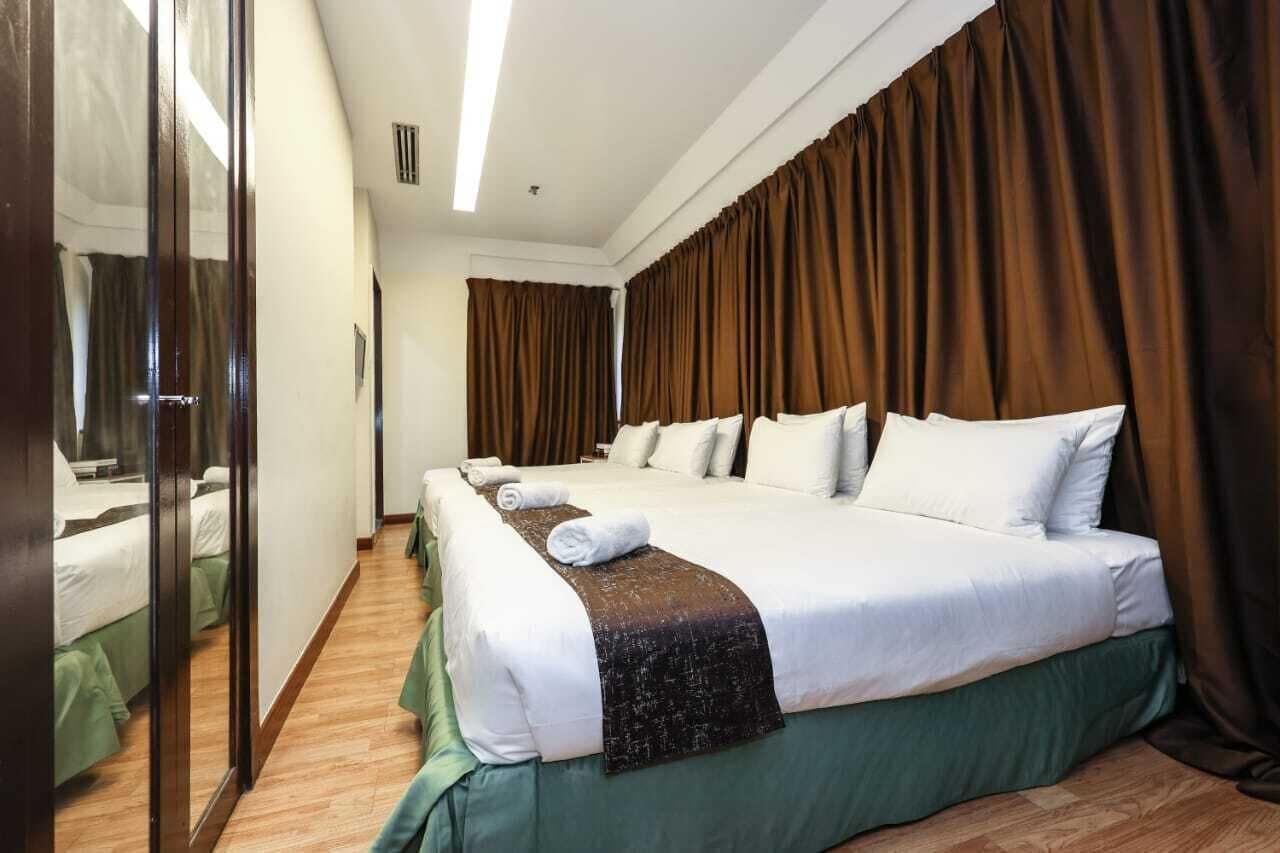 Une chambre d’hôtel avec un grand lit, un miroir et des rideaux.