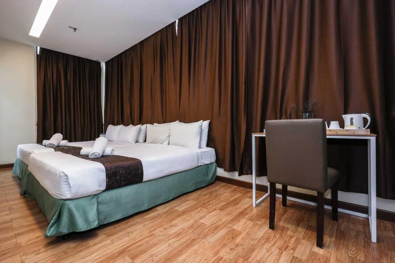 A hotel room with a bed, a desk, and a chair.