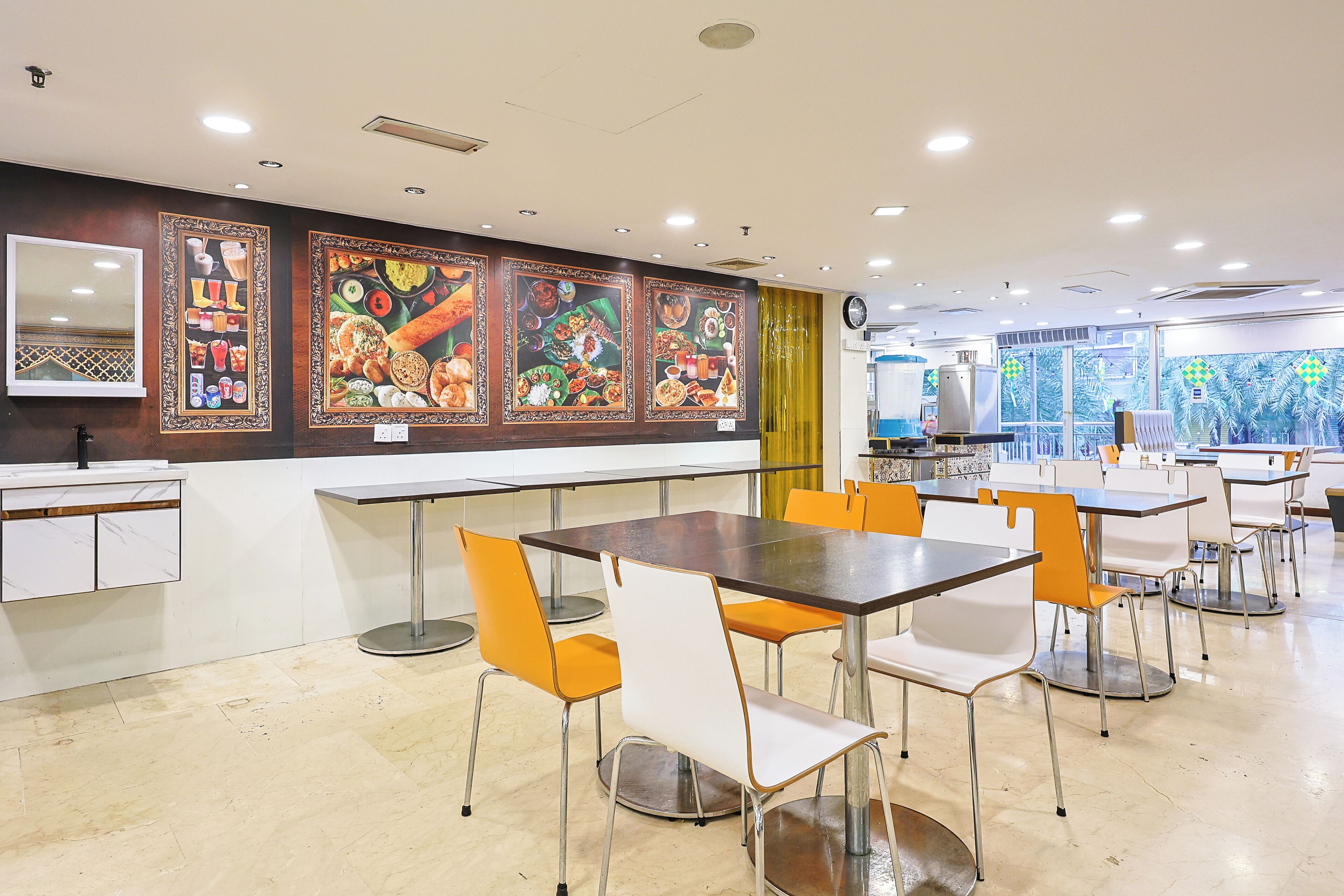 A dining area with tables and chairs, a counter, and decorative wall art.