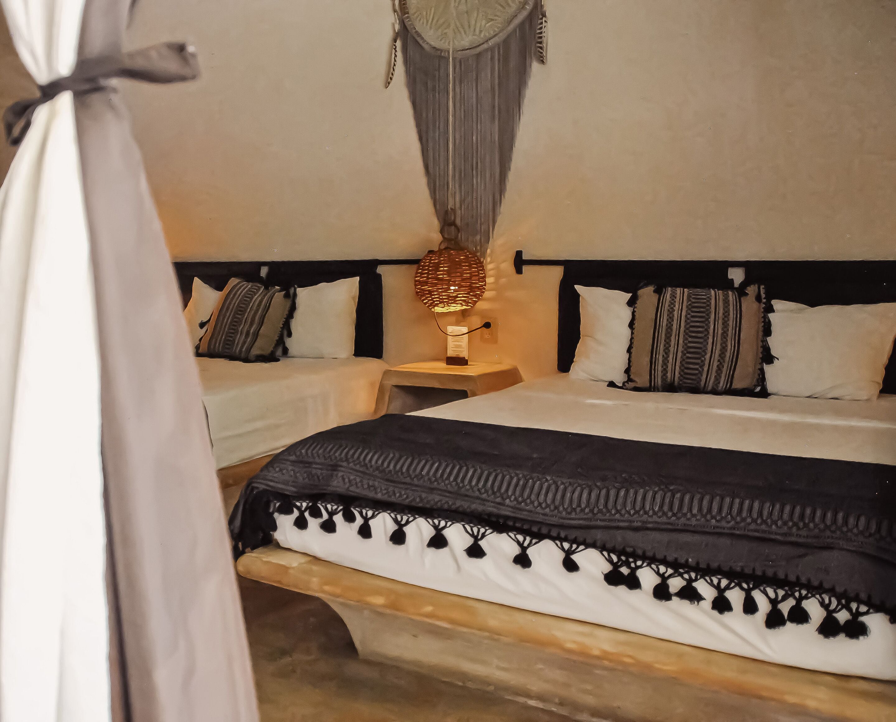 Un dormitorio con cama, mesitas de noche, lámpara colgante y dosel.