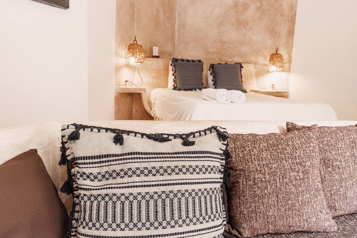 A hotel room with a bed, two bedside lamps, and a view of the room's interior.