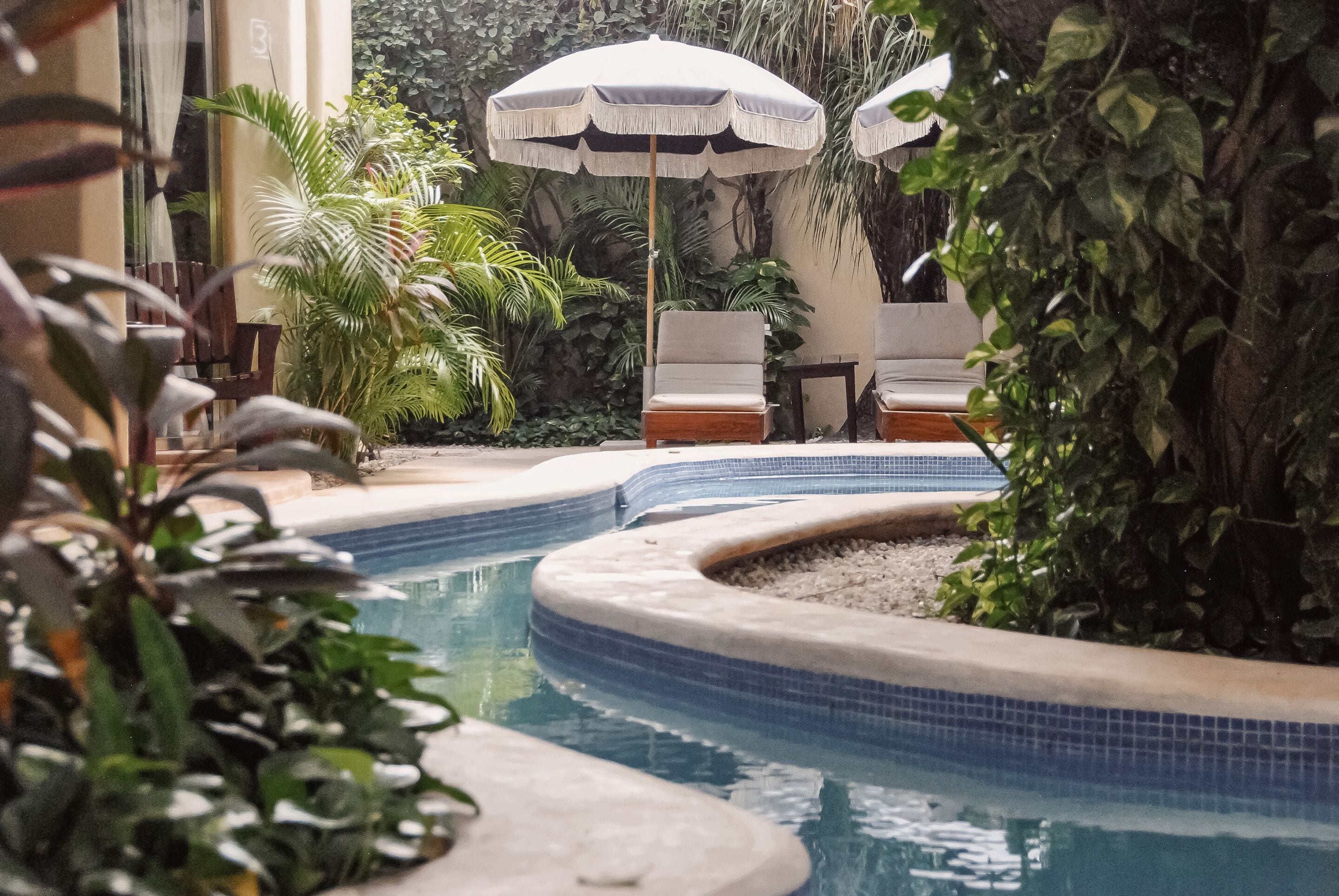 Una piscina al aire libre, sillones reclinables de piscina