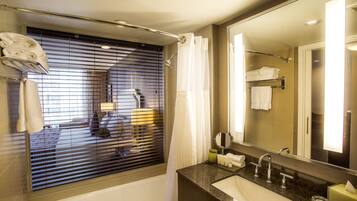 Une salle de bain moderne avec une baignoire, un lavabo et un grand miroir.