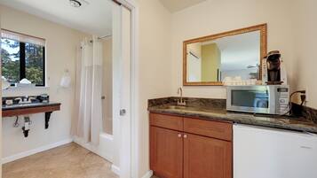 A bathroom with a sink, mirror, and a shower area.