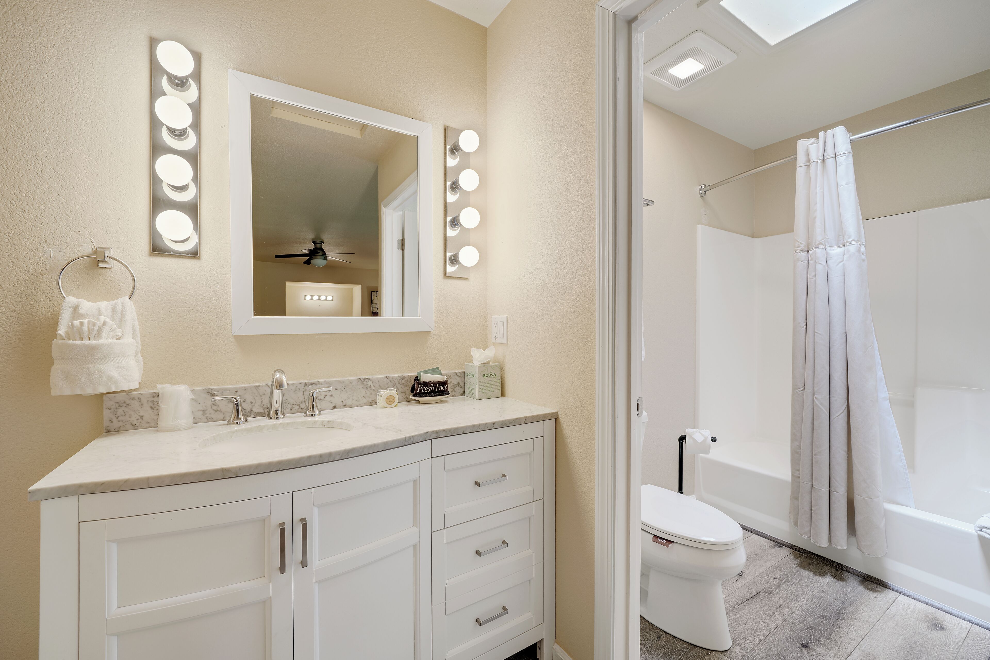 Une salle de bain avec un meuble-lavabo, un miroir et des luminaires.