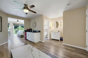 Un amplio salón con ventilador de techo, una mesa de comedor y vistas al exterior.