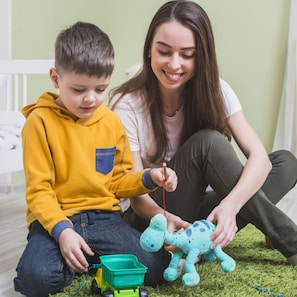 A child playing with a toy truck and a giraffe on a green carpet. - Kempinski Nile Hotel Cairo (Cairo)