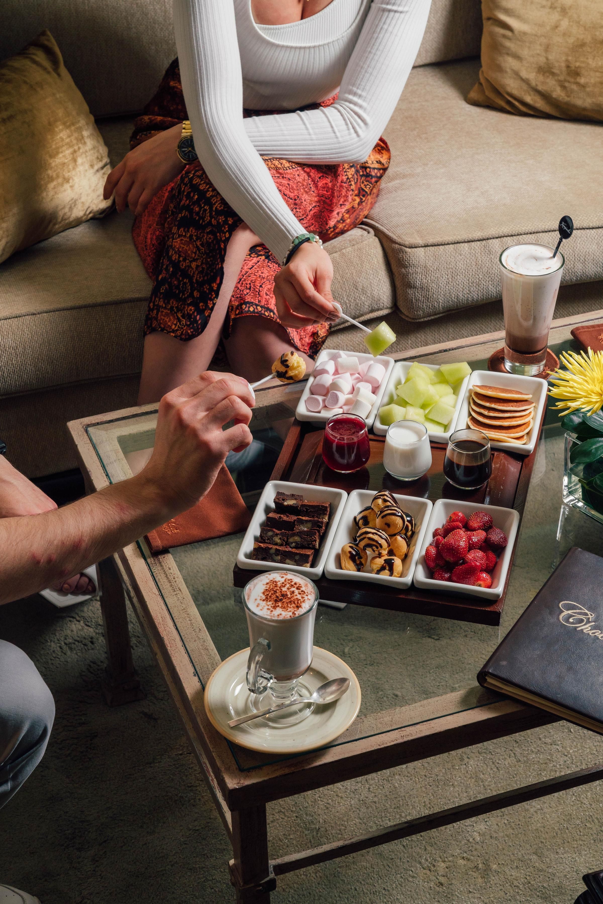 A dining table with a variety of food items and a beverage.