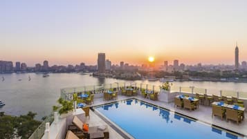 حمّام سباحة خارجي، مظلات على حمّام السباحة، مقاعد للتشمس