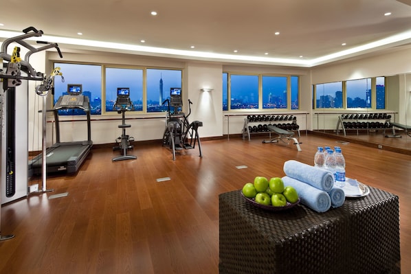 A gym with cardio machines, dumbbells, and a table with apples and towels. - Kempinski Nile Hotel Cairo (Cairo)