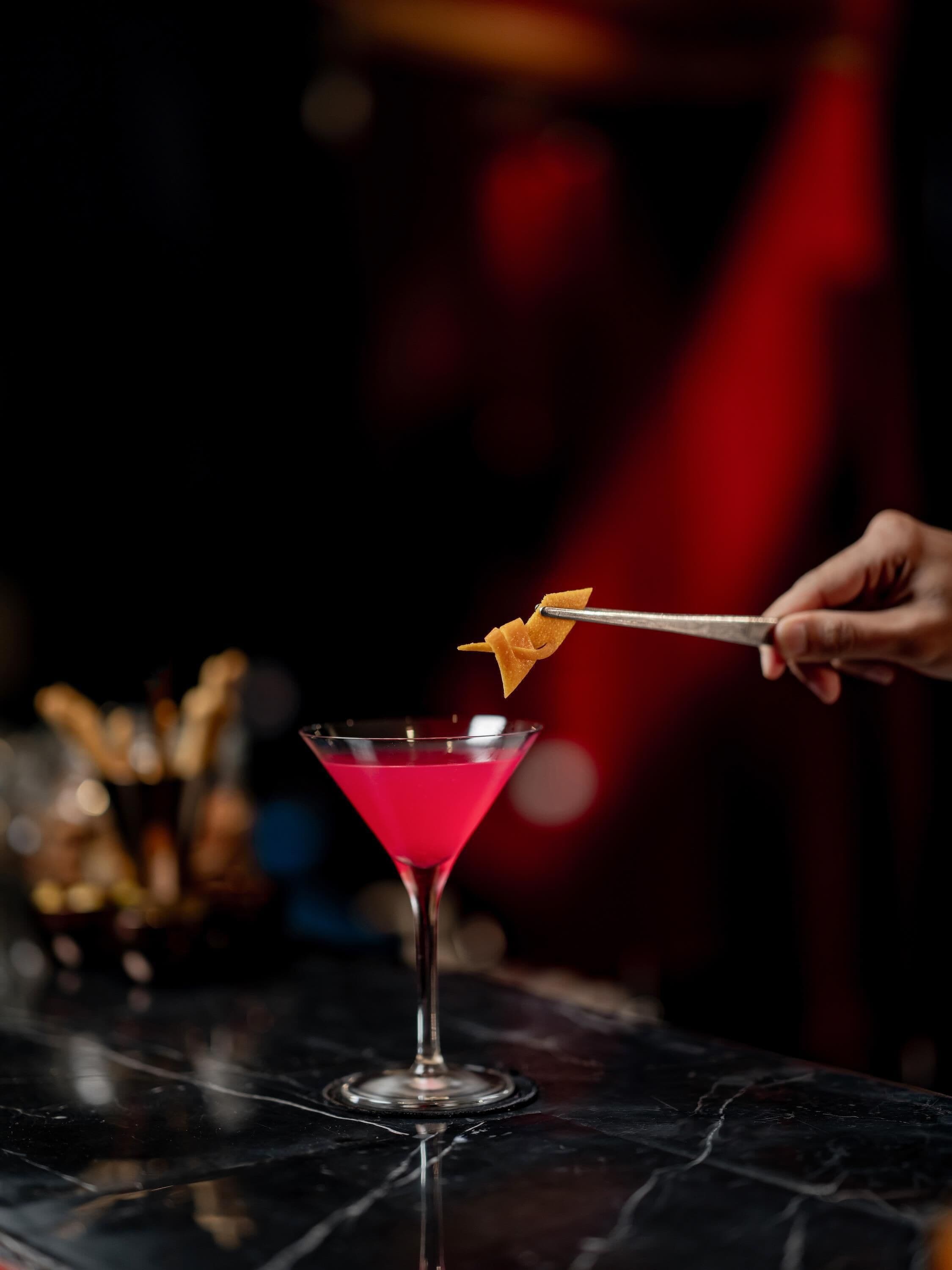 Un verre à martini contenant un liquide rouge, posé sur une surface en marbre.