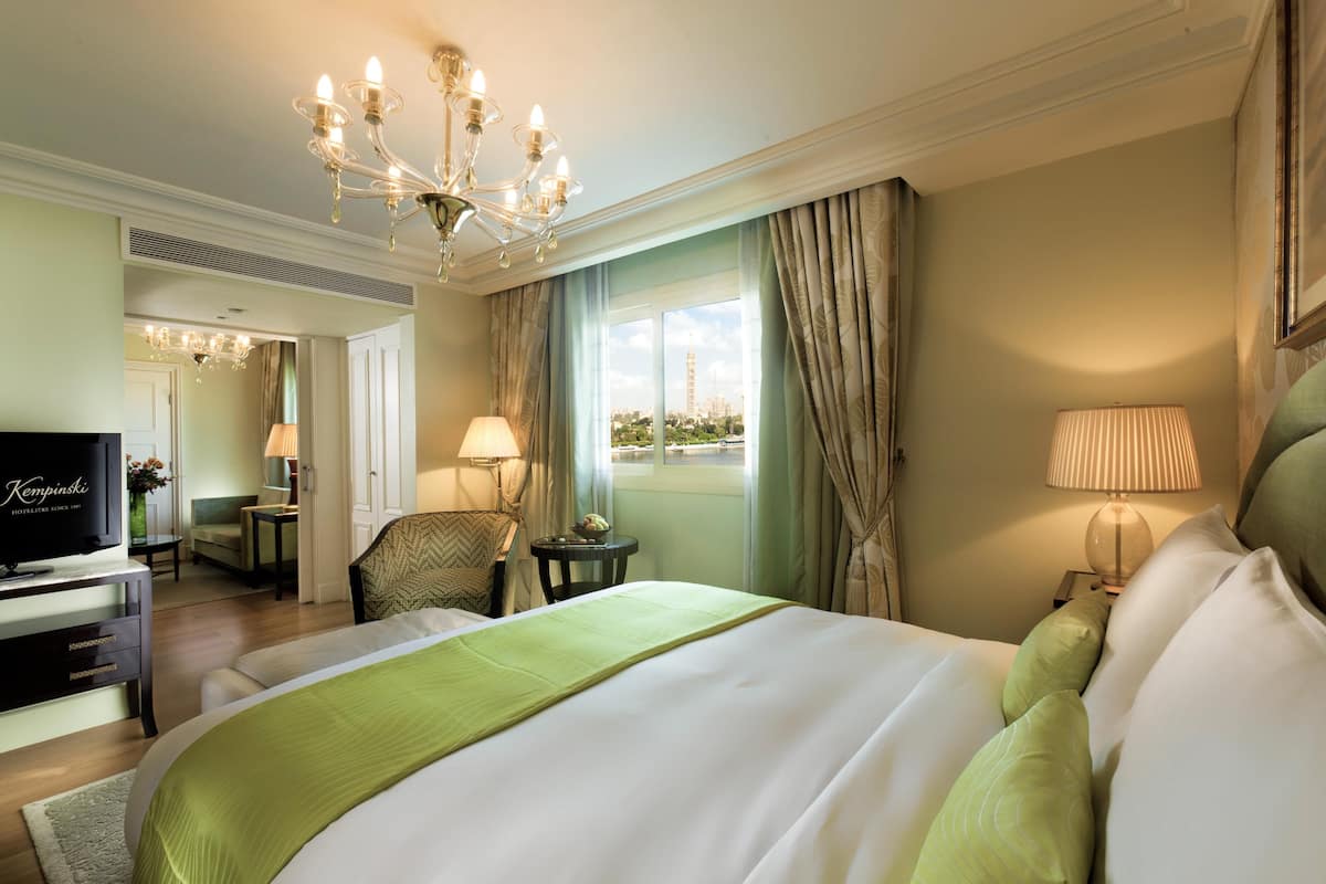 Camera d'hotel con un letto grande, una televisione, una scrivania e vista sulla città.