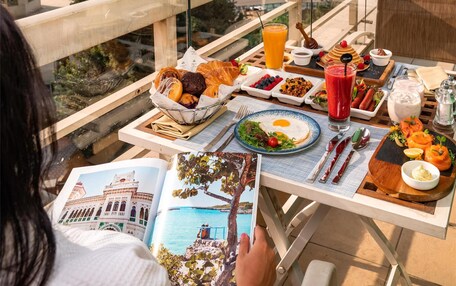 A dining table with breakfast items and a city view.