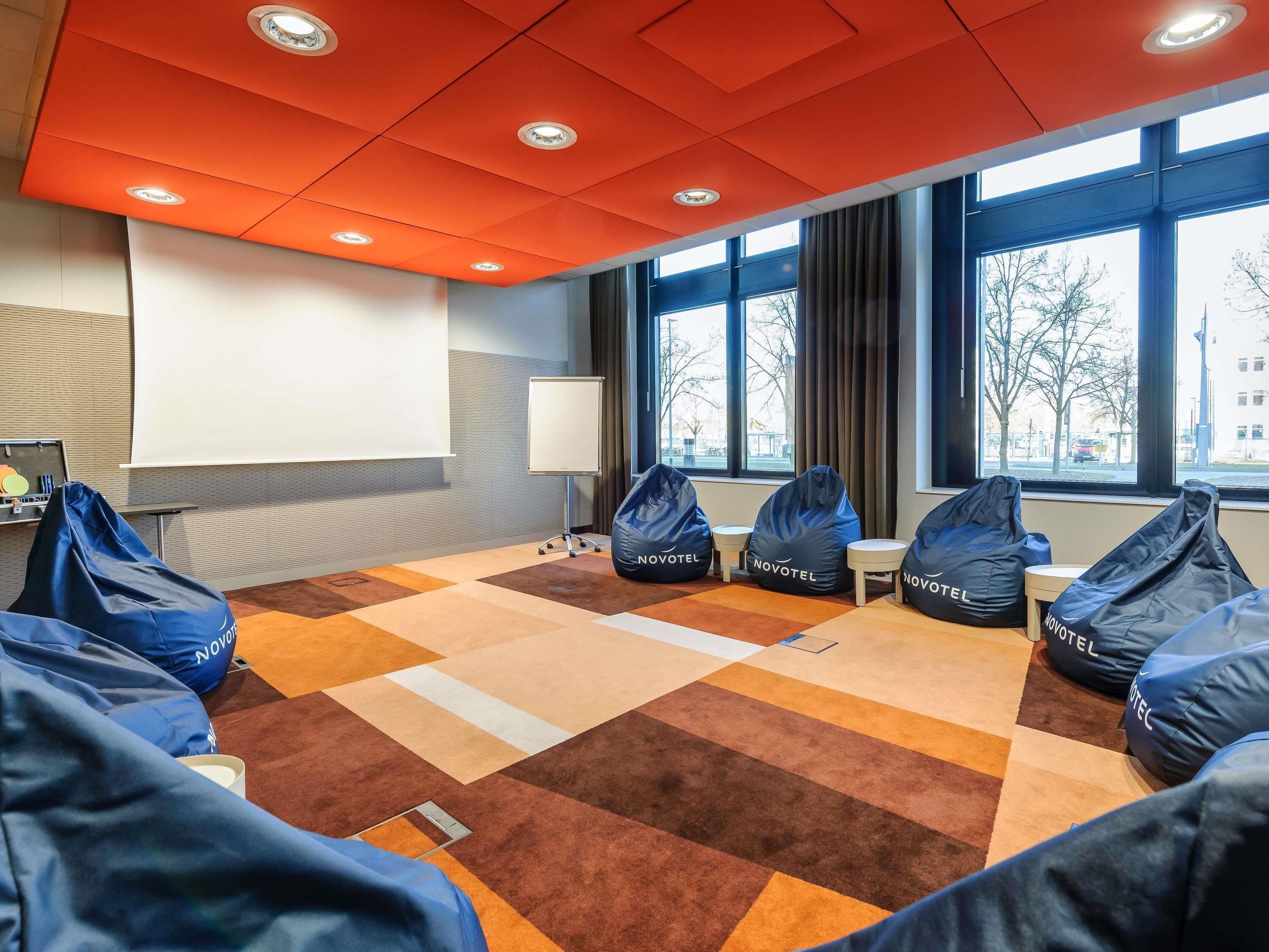A conference room with a whiteboard, projector, bean bags, and large windows.
