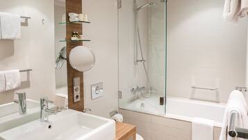 A modern bathroom with two sinks, a glass shower enclosure, and a mirror.