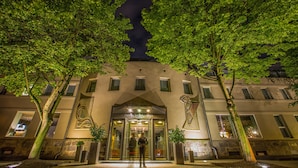 L’entrée d’un hôtel au design moderne, avec une porte en verre et un espace d’accueil chaleureux.