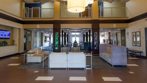 A spacious lobby with a high ceiling, multiple seating areas, and a television screen. - Holiday Inn Express Atlanta Airport West - Camp Creek Market by IHG (Atlanta)