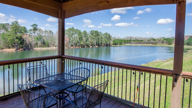 A covered outdoor area with a table and chairs overlooking a lake. - Holiday Inn Express Atlanta Airport West - Camp Creek Market by IHG (Atlanta)