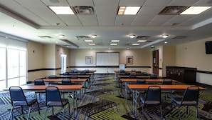 A conference room with a large table, chairs, a projector screen, and a carpeted floor. - Holiday Inn Express Atlanta Airport West - Camp Creek Market by IHG (Atlanta)