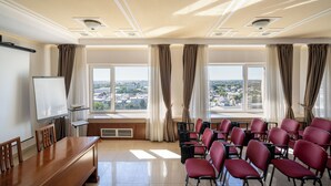 A conference room with a large table, multiple chairs, a whiteboard, and large windows with curtains. - Traian Braila (Braila)