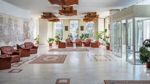 A spacious lobby with leather sofas, a patterned rug, and a large wall mural. - Traian Braila (Braila)