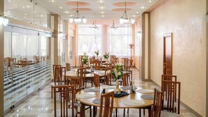 A spacious dining area with multiple tables and chairs, large windows with natural light, and a modern ceiling design. - Traian Braila (Braila)