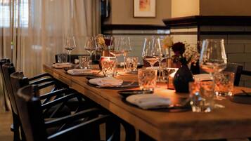 A dining table set with multiple wine glasses, a candle, and a vase with flowers.