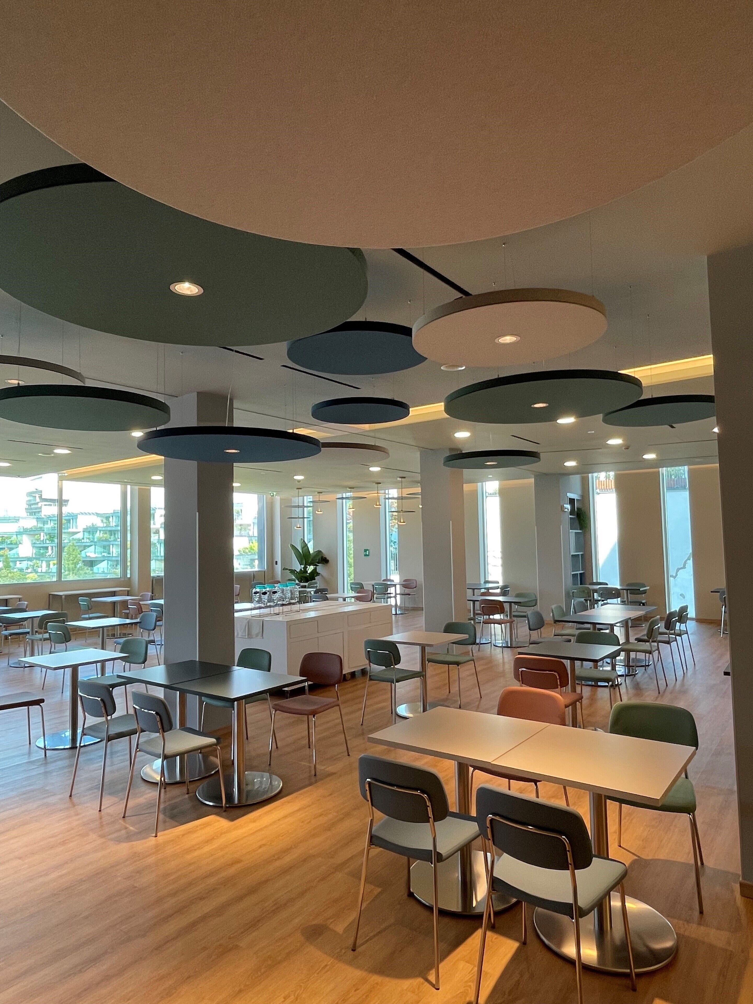 Un'ampia sala da pranzo con arredi moderni, ampie finestre e un'isola centrale.