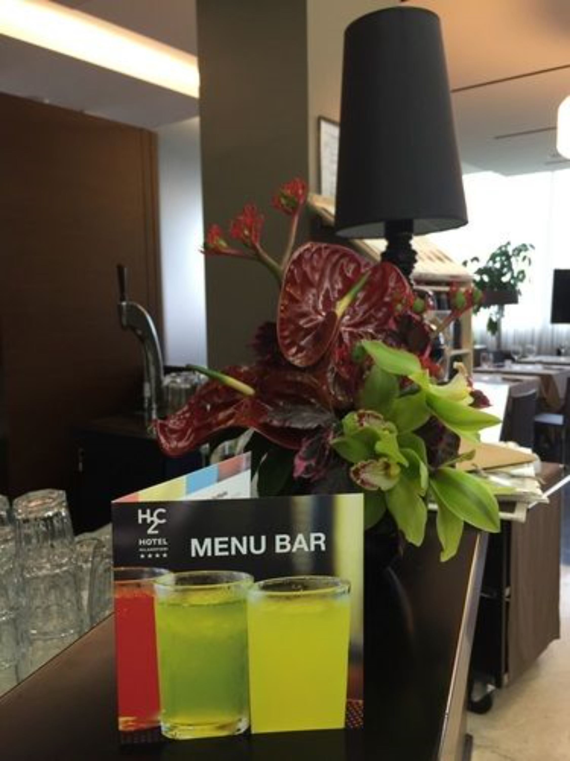 Une chambre d’hôtel équipée d’un mini-bar, d’un panneau indiquant le menu des boissons et d’une plante décorative.