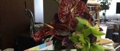 Une chambre d’hôtel équipée d’un mini-bar, d’un panneau indiquant le menu des boissons et d’une plante décorative.