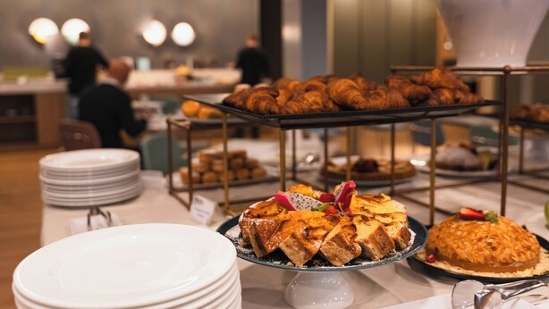 A buffet with various baked goods and a cake on display.