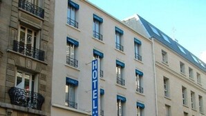 A hotel with a prominent 'HOTEL' sign, multiple windows, and a blue awning with the name 'Hotel de los Pares'.