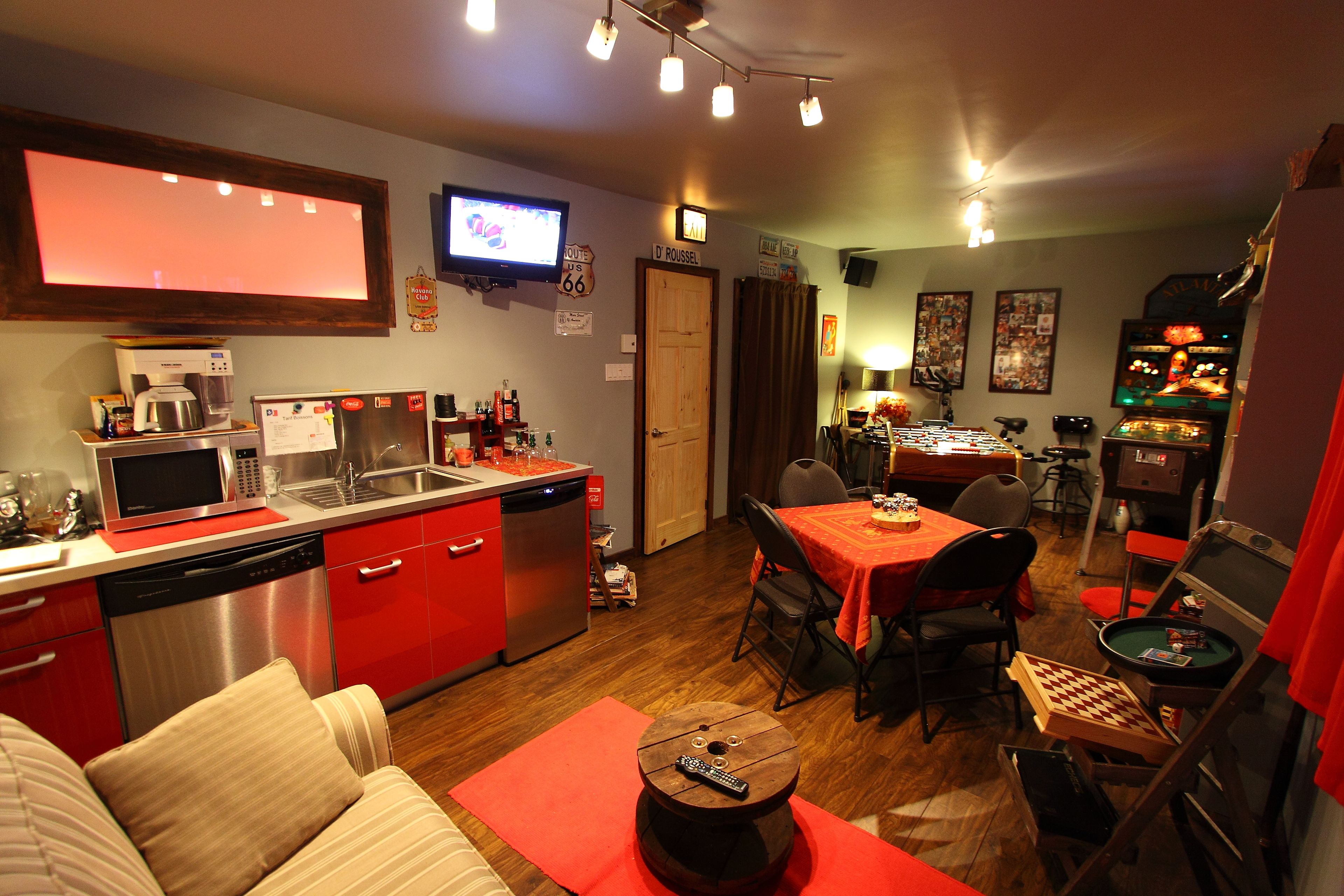 Un espace de vie compact comprenant une kitchenette, un coin repas et un petit espace dédié aux loisirs.
