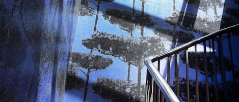 Una escalera con barandilla y un muro decorado con un diseño de árbol.