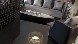 A modern living room with a grey sofa, a coffee table, and a decorative lamp.
