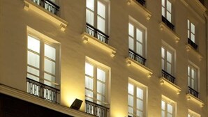 A multi-story hotel with a classic facade, large windows, and balconies.
