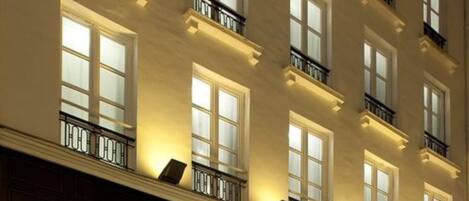 Un hotel de varios pisos con una fachada clásica, grandes ventanas y balcones.