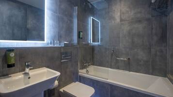 A modern bathroom with a sink, toilet, and bathtub, all with metallic fixtures.
