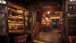 Un espace bar avec des tabourets, un comptoir et une enseigne indiquant le « Penny Bar ».