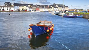 Un port où des bateaux sont amarrés, avec une rangée de bâtiments en arrière-plan.