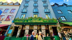 Un bâtiment doté d’une marquise verte sur laquelle on peut lire les inscriptions « M. FitzGeralds » et « Musique en direct ».