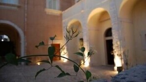 A courtyard with arches and a building facade. - Hotel Palazzo Gambuzza - Ispica (Ispica)