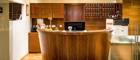 A modern kitchen with a central island, wooden cabinets, and a built-in wine cooler.