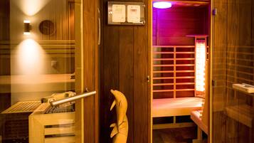Una sala de sauna con paredes de madera, un banco y un panel de control en la pared.