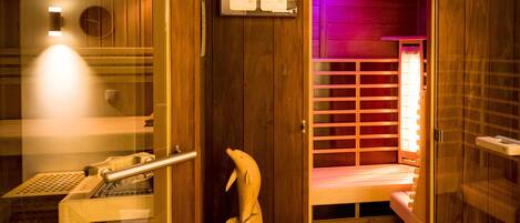 A sauna room with wooden walls, a bench, and a wall-mounted control panel.