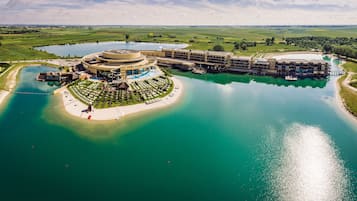 A large hotel with a circular central building, multiple wings, and a surrounding water body.