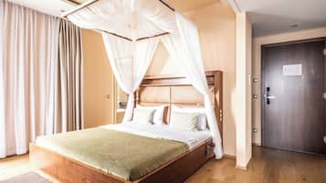 A bedroom with a wooden bed, a canopy, a wooden door, and a view of the hallway.