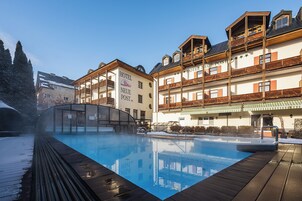 Una piscina al aire libre, sombrillas, sillones reclinables de piscina