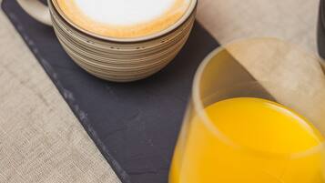 A table with a coffee cup, a glass of orange juice, and various dishes.